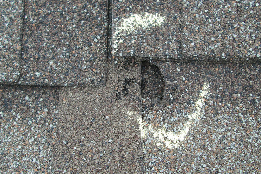 Visible dent in shingle roof from hail damage